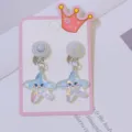 Close-up detail of cute glitter star clip-on earrings for kids, sparkling resin design. - Seastar Carded / Light White Blue