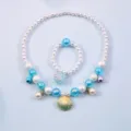 Detailed view of children pearl necklace bracelet set with seashell charm and blue beads. - Shell 2-Piece Set (Cardboard) / Blue