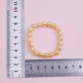 Gold crystal beaded bracelet with 8mm beads, 20 pieces, 16cm circumference detail view. - Yellow