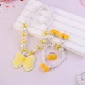 Detailed view of kids pearl jewelry set featuring yellow bows necklace bracelet ring accessories. - Bow 5-Piece Set (Transparent Bag) / Yellow