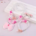 Detailed view of kids pearl necklace, bracelet, ring, and cute pink bow resin charm set. - Bow 5-Piece Set (Transparent Bag) / Pink