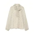 Vue détaillée du chemisier chic à pois avec un col noué gracieux et de longues manches. - XS / Hauts / Pois Blanc Cassé