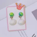 Close-up of children's clip-on earrings featuring cute colorful seashells and mermaid scales. - Green Diamond Shell