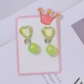 Green heart crystal clip-on earrings detail shot showing lovely design for kids non-pierced ears. - Green Heart