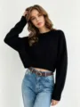 Detail view of a black cropped knit sweater with round neck, soft texture and comfortable fit. - One Size / Black