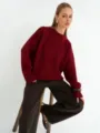 Vista dettagliata di un morbido maglione bordeaux con vestibilità rilassata e coste. - Taglia unica / Borgogna