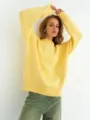 Primo piano dettagliato di un morbido maglione in maglia gialla con una consistenza raffinata. - Taglia unica / Giallo
