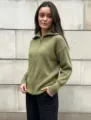 Close-up of olive green knitted zip-up cardigan showing ribbed texture and collar. - One Size / Olive Green