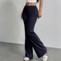 Detail view of women high waist dark blue casual flare pants worn by a model indoors. - S / Bottoms / Navy Blue