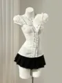 Vista detallada del top blanco de manga abullonada con botonadura y falda a juego. - S / Tops / Blanco