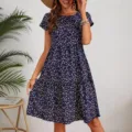 Detailed view of the women's short sleeve floral round neck tiered dress in blue. - S / Dresses / Dark Blue