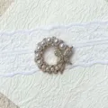Detailed view of the elegant pearl butterfly rhinestone brooch and gemstone base tray accessory. - Butterfly Wreath Brooch / Gold