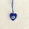 Gedetailleerde close-up van blauw boze oog hart glas hanger, traditioneel Turks amulet. - Hart