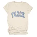 Detailopname van de blauwe bloemige TEACH letter grafische print op het beige t-shirt. - Tops / Zandkleur / S