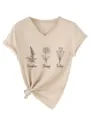 Close-up van botanische print V-hals korte mouw t-shirt met stijlvol knoopdetail aan de zoom. - Zandkleur