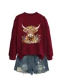Maroon sweatshirt featuring a highland cow floral graphic paired with distressed denim shorts. - S / Tops / Burgundy