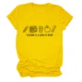 Gros plan détaillé du t-shirt enseignant jaune avec un graphique mignon et une citation. - S / Hauts / Jaune (Graphisme couleur avec texte noir)
