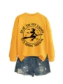 Detailansicht des gelben Sweatshirts mit Hexen-Print und ausgefransten Jeansshorts. - S / Oberteile / Gelb (Schwarzer Druck)