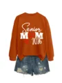 Vue détaillée du sweat-shirt orange Senior Mom 2026 associé à un short en jean déchiré. - S / Hauts / Orange Brûlé (Impression Blanche)