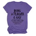 Dettaglio di t-shirt viola a maniche corte con stampa di citazione divertente da insegnante. - Taglia S / Top / Viola (Testo Nero)