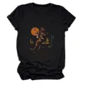 Vista dettagliata della stampa cowgirl vintage su questa elegante t-shirt nera a maniche corte. - Taglia S / Top / Borgogna