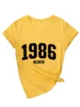Dettaglio della maglietta da donna gialla a maniche corte con scollo a V e grafica 1986. - Taglia S / Top / Giallo