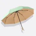 Klappbarer 3-teiliger Regenschirm mit UV-Schutz, hellgrüne Farbvariante, 8 Rippen. - 3-fach faltbarer manueller Regenschirm mit 8 Streben, Holzgriff und Farbbeschichtung in Kaltgrün