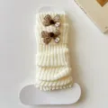 White knitted leg warmers featuring cute brown polka dot bows, cozy winter fashion accessory. - One Size / White