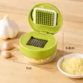 Manual press garlic chopper with stainless steel grid and container for easy kitchen cooking. - 1 Piece/Pack / Green