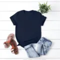 Vista detallada de una camiseta de manga corta azul marino lisa con accesorios de fondo plano. - S / Negro