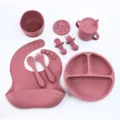 Silicone baby feeding set with divided plate, bib, spoon, fork and cup for toddler mealtime. - Silicone 8-Piece Set / Brick Red