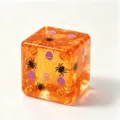 Close-up detail of Halloween squishy cube toy with glitter, spider, pumpkin, and skull. - Orange