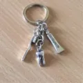 Detailed shot of metal dentist keychain charms including toothbrush, tooth, and toothpaste pendant. - Dental Theme Style