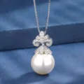 Primo piano dettagliato di elegante collana con ciondolo di perla e zirconi lucidi. - Collana con ciondolo / Bianco