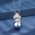 Primo piano sui dettagli della squisita ciondolo con pavé di diamanti e collana di perle scure. - Collana con ciondolo / Grigio
