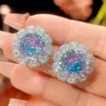 Nahaufnahme von funkelnden Farbverlauf Kristall Blumen Ohrsteckern mit Zirkonia. - Ohrstecker Paar / Hauptstein 12x12mm / Hellblau