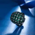 Close-up detail of the luxury black gold plated dome ring featuring dense green and white crystal cluster. - Ring (ZS687) / Green