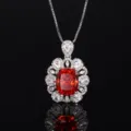 Vista ravvicinata e dettagliata di un meraviglioso ciondolo con gemma rossa e zirconi bianchi. - Collana con ciondolo / arancio-rosso