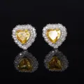 Detailaufnahme von funkelnden herzförmigen gelben Diamant-Ohrringen mit eleganter Silberfassung. - Eisschliff Gelb Diamant Ohrstecker