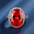 Squisito anello di lusso con gemma rossa ovale e alone di zirconi scintillanti nei dettagli. - Stile Rosso Arancio (ZS547) / Anello Rosso Arancio