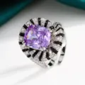 Gros plan détaillé d'une bague statement créative en pierre précieuse violette taille coussin. - Violet