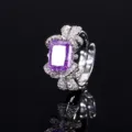 Close-up van de paarse edelsteenring, waarbij de sprankelende strikdiamantdetails opvallen. - Paarse Ijsgesneden Strass Ring