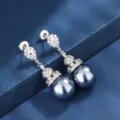 Primo piano dettagliato dei raffinati orecchini pendenti con perle scure e luminosi zirconi. - Orecchini a Bottone con Perle Grigie
