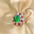 Detailed close-up of a stunning green cabochon gemstone ring with red and clear zirconia stones. - Green Chalcedony Ring