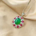 Stunning oval green cabochon pendant necklace with vibrant red and clear stone halo design. - Green Faux Chalcedony Pendant With Chain