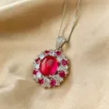 Closeup of the stunning pigeon blood red cabochon corundum pendant with sparkling halo. - Red Corundum Pendant With Chain