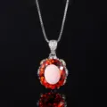 Close-up detail of luxury orange-red oval gemstone pendant necklace with brilliant sparkle. - Orange Red Pendant With Chain