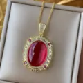 Detailansicht einer vergoldeten Vintage-Halskette mit rotem Edelstein und Zirkonrahmen. - Rubinroter Anhänger mit Kette / Gold