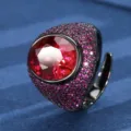 Close-up detail of bold oval red gemstone statement ring with micro-pave stones and black gold finish. - Oval Main Stone (ZS1149 Black Gold) / Black Gold Synthetic Red Corundum Ring