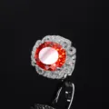 Elegante anello da donna con gemma rossa ovale e alone di diamanti scintillanti incastonati. - Anello Arancio Rosso Taglio Cushion